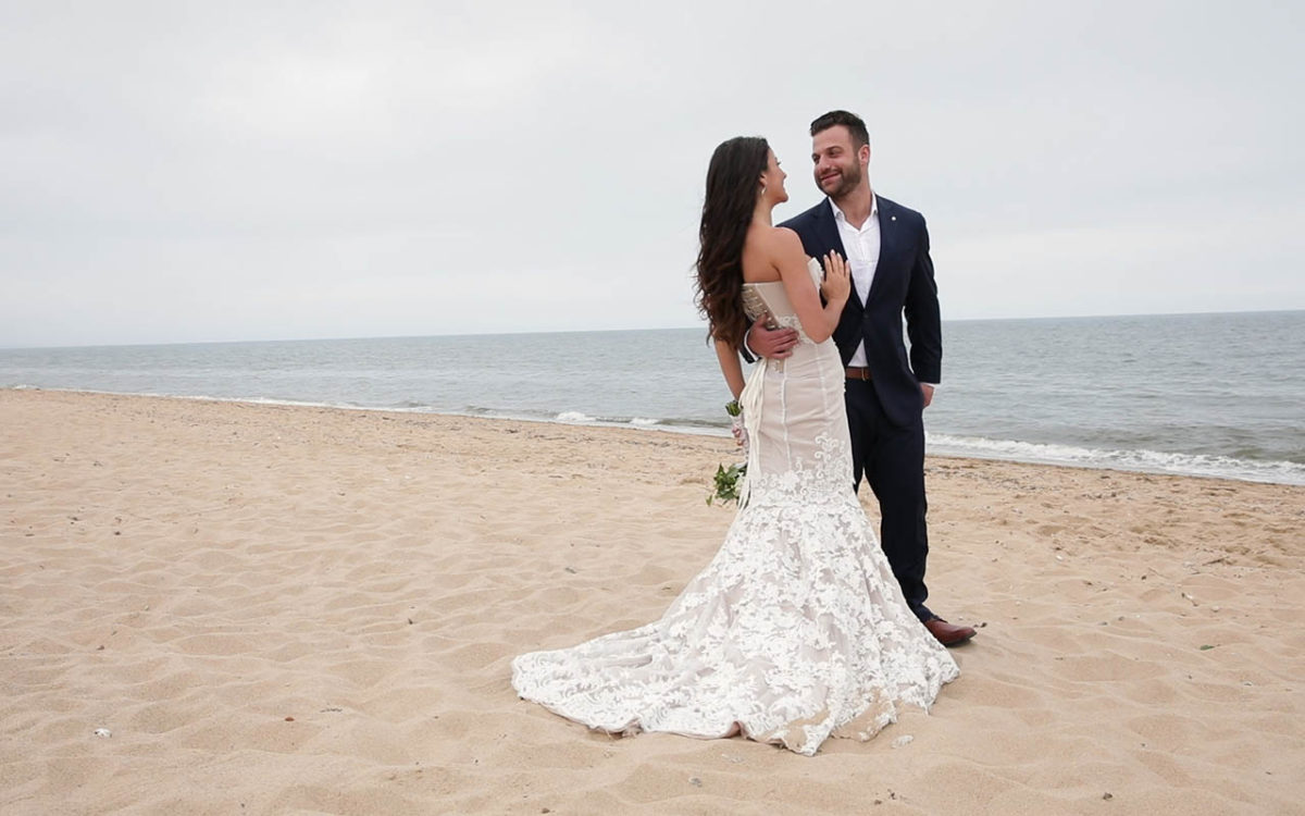 Happy bride and groom smiling while on a Cape Cod beach