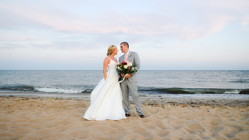 Bride and Groom having photos taken at Popponesset Inn on the beach