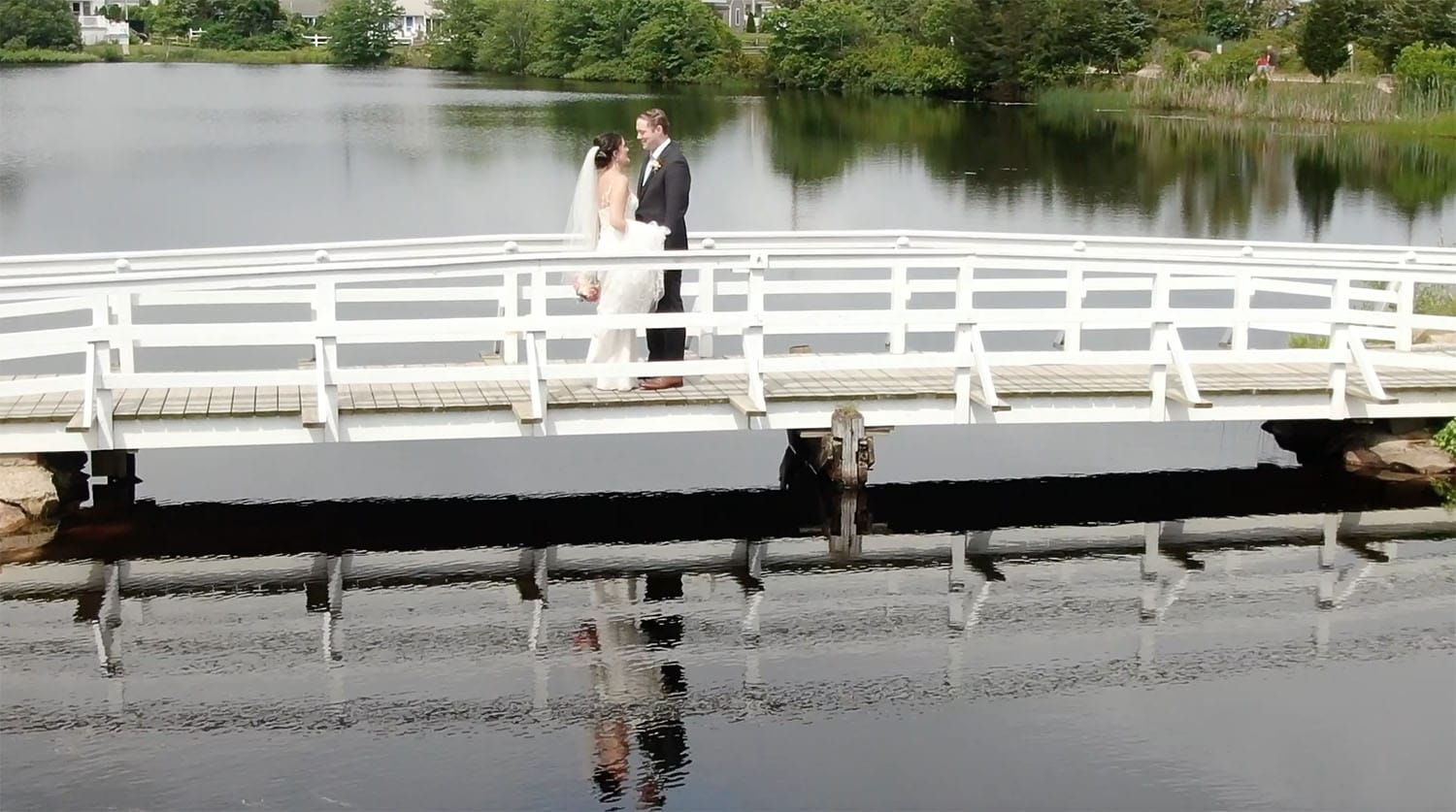 Cassidy + John Popponesset Inn Wedding with their first look on a nearby bridge